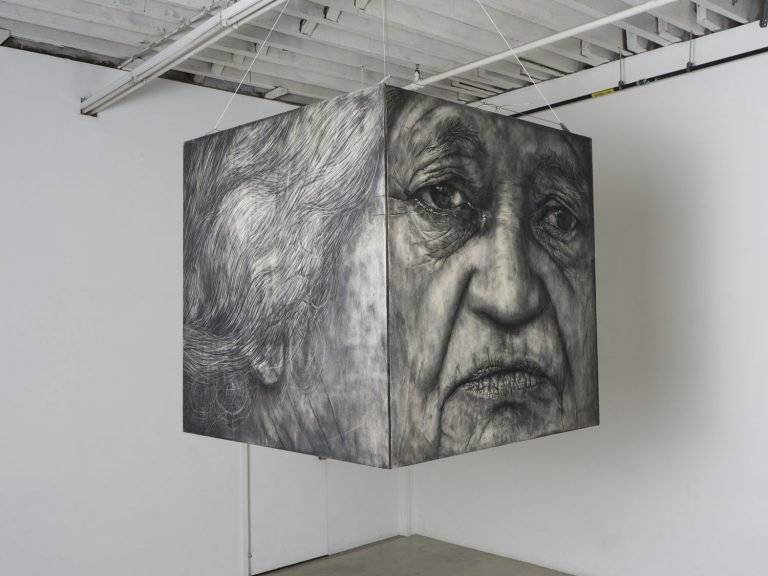 Cube with a printed black and white face suspended from the ceiling.