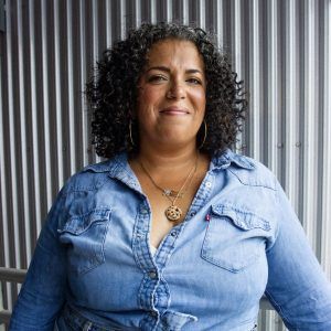 A photo of artist Christina Delgado smiling at the camera.