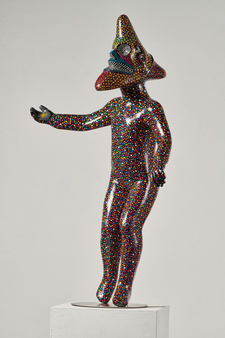 Figure with an object head painted in the style of a vejigante.