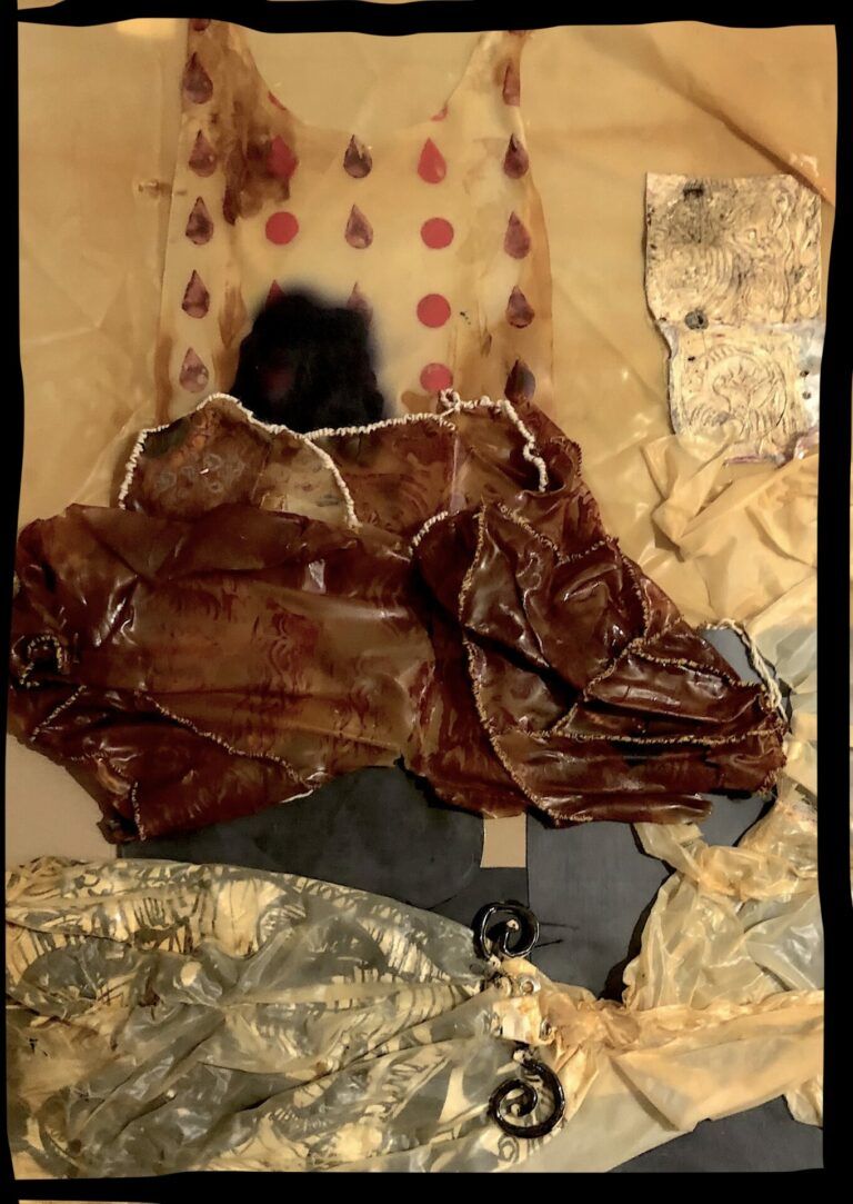 Latex, paper, and metal scraps laid next to one another. The image has a sepia tone and the objects look old.