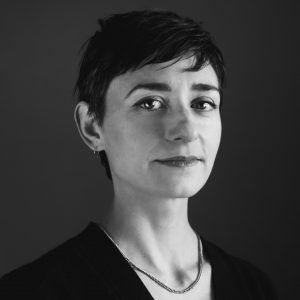 A grayscale photo of artist Gabriela Salazar. She looks into the camera with a open, neutral expression.