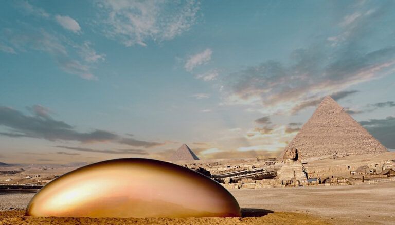 Engineered aerospace carbon fiber with gold particles shaped like a rounded mound. The sculpture is next to the Sphinx and the Pyramids.
