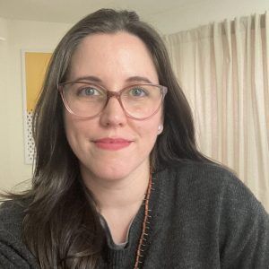 A close up photo of artist Kristine Servia. She wears glasses and smiles at the camera.