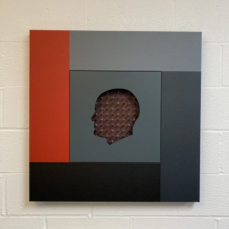 A cut-out silhouette of a man facing left. There is a textured fabric inside the hollow area. Surrounding the portrait are red, black, dark grey, and light grey rectangles, making a square composition.
