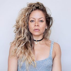 A headshot of artist Mónica Félix. She looks into the camera with a neutral expression.
