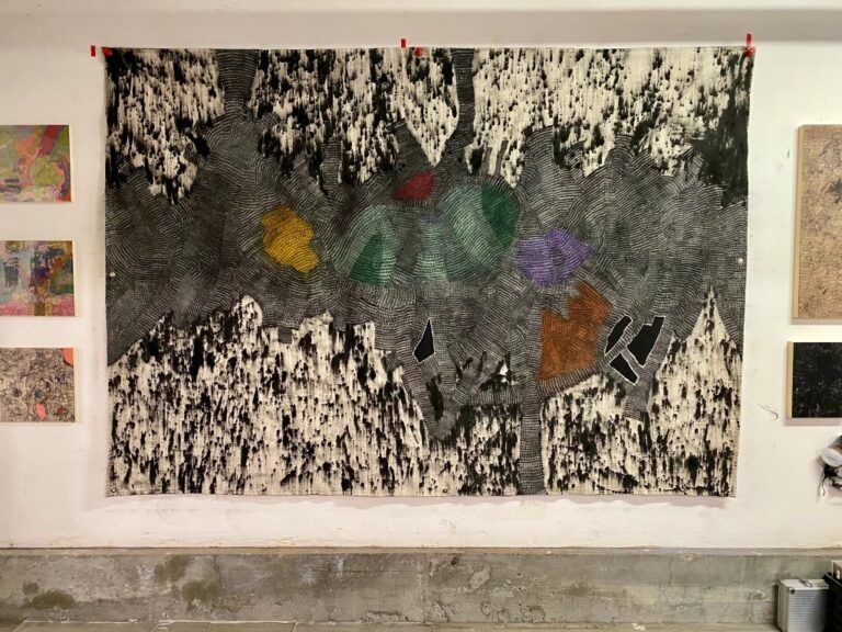 black & white abstract painting, colorful shapes are floating in the middle of dense line work. Outside of the dense lines there are paint splatters.