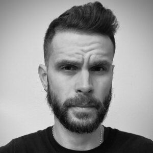 A close up grayscale photo of artist Andrè Pagano