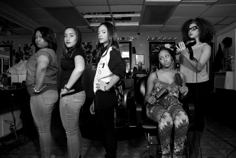 "Commissioned by Mark Ugbomah for this album: "Distinguishing Gray". This scene was inspired by the concept of straightening hair in Caribbean cultures as the sign of social status, and an affliction to beauty standards that are not natural to most Dominican or Puerto Rican woman. My photographic commentary in this scene is the assembly line of blown out hair dos, the irony by a woman with natural hair herself. Will she succumb too?" - Melanie Gonzalez