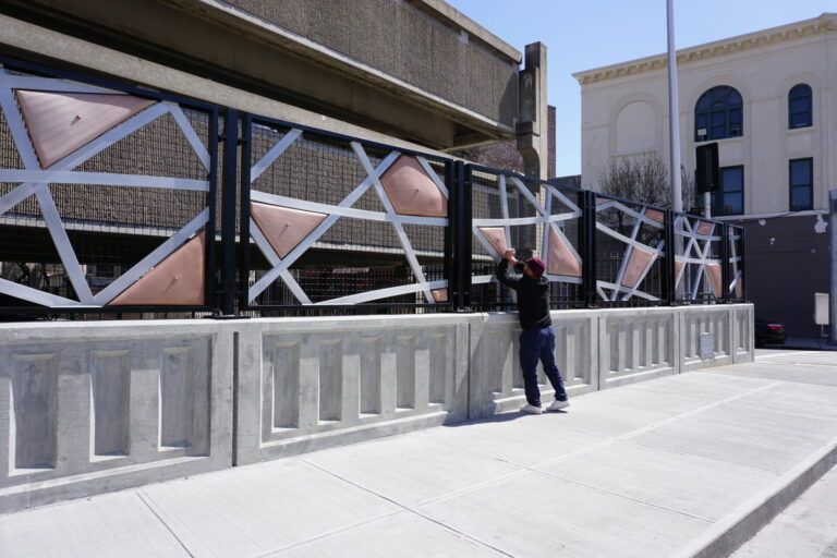 Detail of "CROSSCUT." Geometric shapes cut to make a fence-type sculpture. The shapes mimic percussion instruments, meant to play by hand.