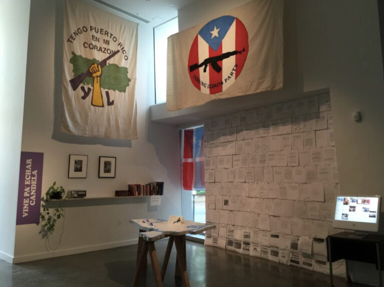 "In the installation, there are books about contemporary and past movements such as Occupy Wall Street and the Young Lords. The “office” includes a computer displaying a social media hashtag aggregator to contemporary issues such as #blacklivesmatter and a radio playing live WBAI programming in the background. In addition, the “office” includes a table map of New York City where visitors can map sites of struggle and FBI files on the Young Lords and Puerto Rican independence movements." - Hatuey Ramos-Fermín