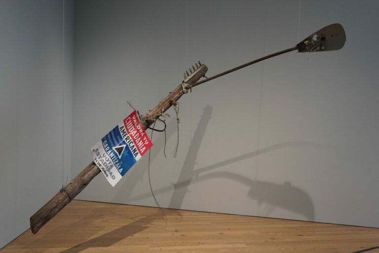 Hurricane ravaged wooden electric post with statehood propaganda.