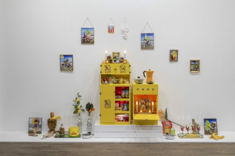 An altar with items from the common Puerto Rican kitchen including pots, spices, coffee, and glasses.