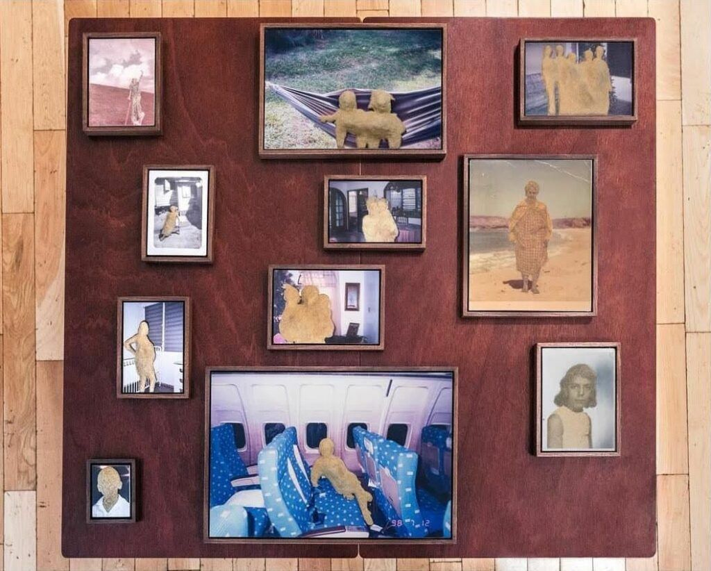 The full collection of sand portraits titled "islotes" in frames arranged on dark wood.