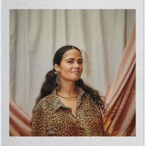 Rebel Betty wearing leopard print in front of pink and white drapes.