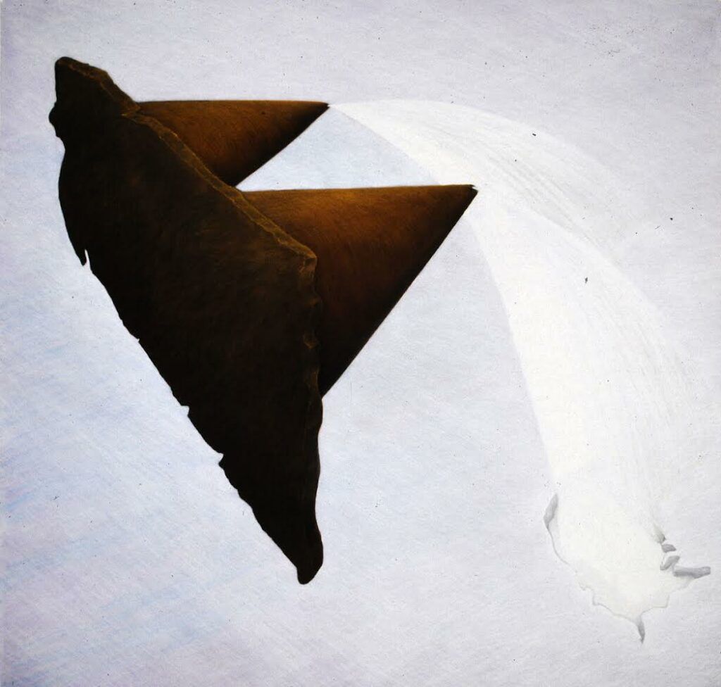 A dark form with two points and sprays of white coming from the tips.