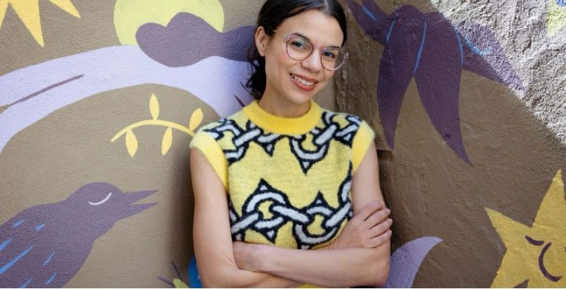 Cindy Lozito wearing a spiked chain patterned sweater smiling for her portrait.