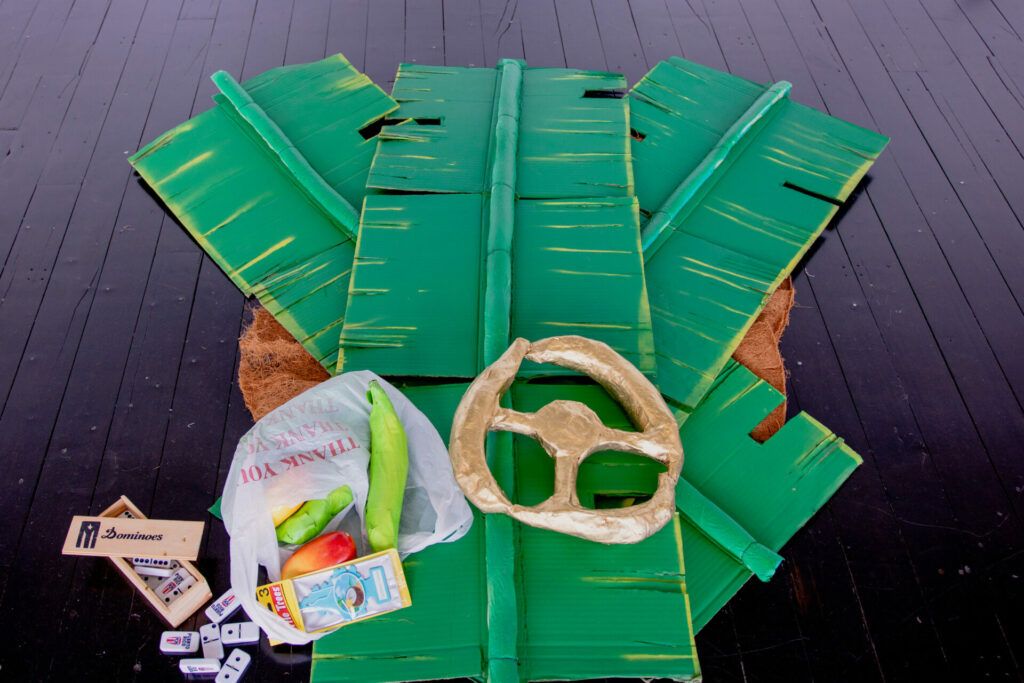 Detail: gold steering wheel, fruit in a plastic bag, dominos.