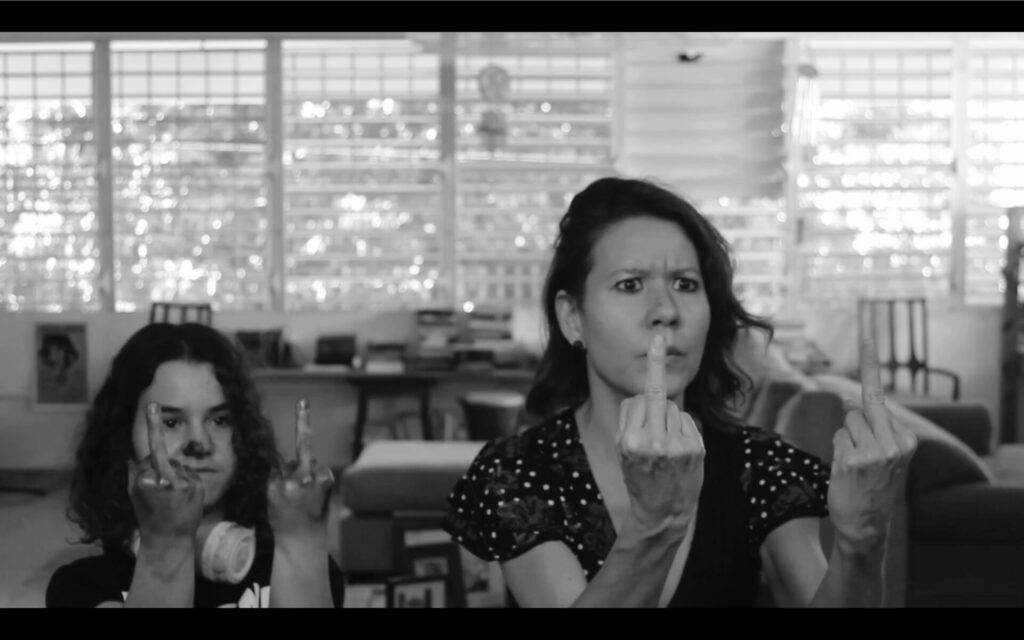 A young girl and her mother giving double middle fingers.