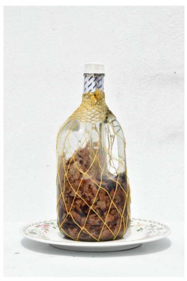 Glass jar covered in fish nets, filled with ingredients and spices.
