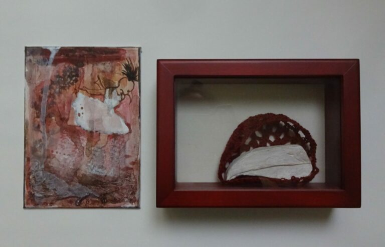 Wall mounted sculptural works featuring a red box, crochet, and paint.
