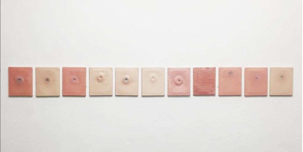 Ceramic pink orifices lined up on the wall in neat rectangles.