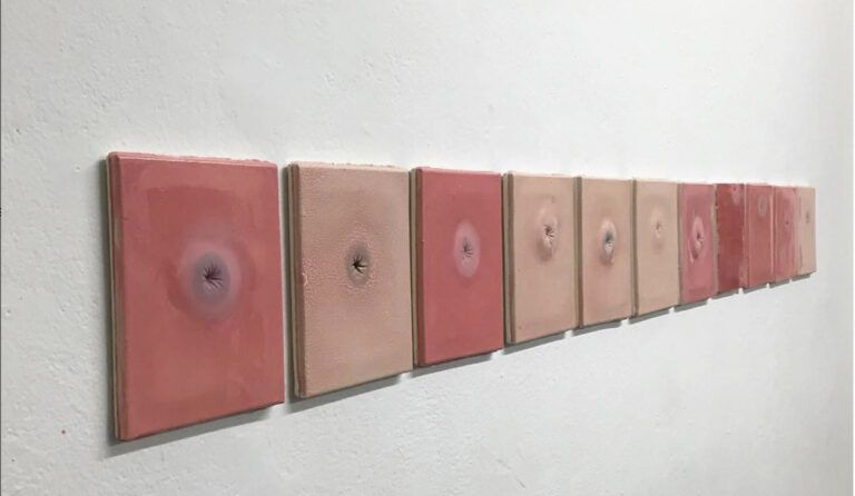 Ceramic pink orifices lined up on the wall in neat rectangles.