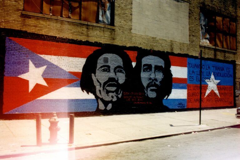 A mural of the Puerto Rican flag and the Cuban flag featuring the painted faces of the two revolutionaries.